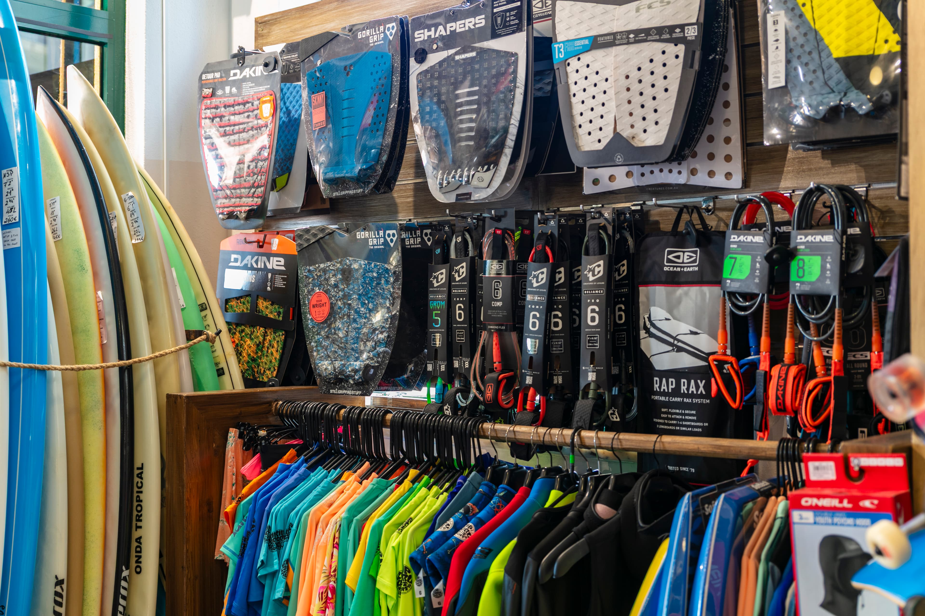 Equipamento, camisolas e pranchas de surf dentro da loja da Rocha Beach House.