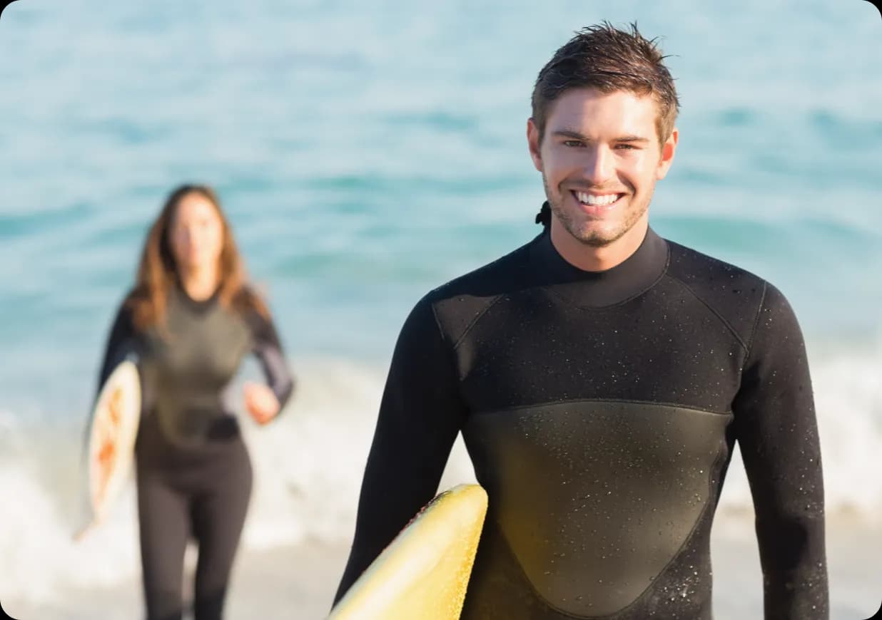 Two people in black wetsuits.
