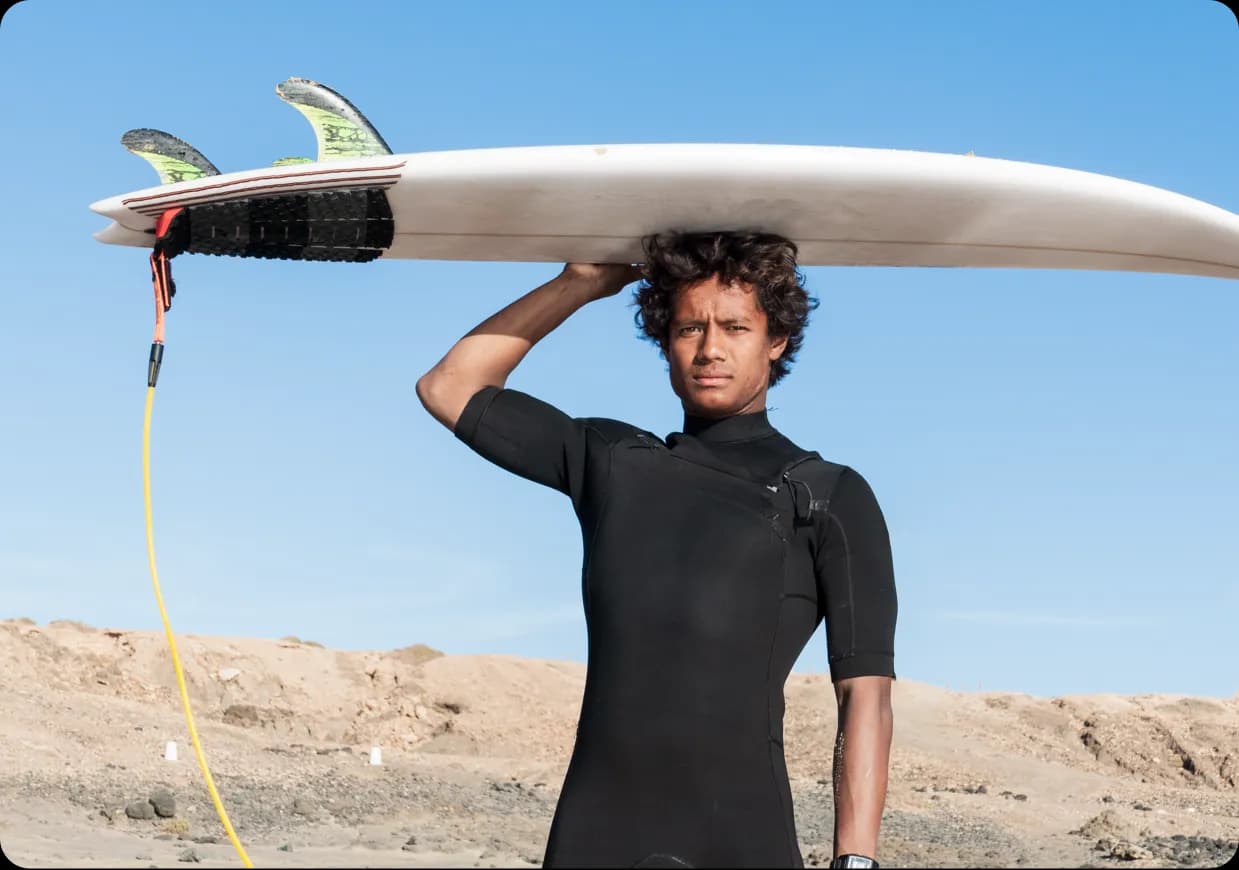 A man holding a surfboard over his head.